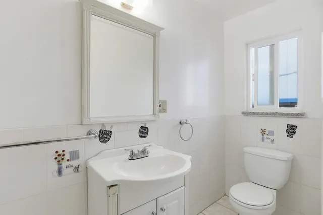 a bathroom with a sink a toilet and mirror