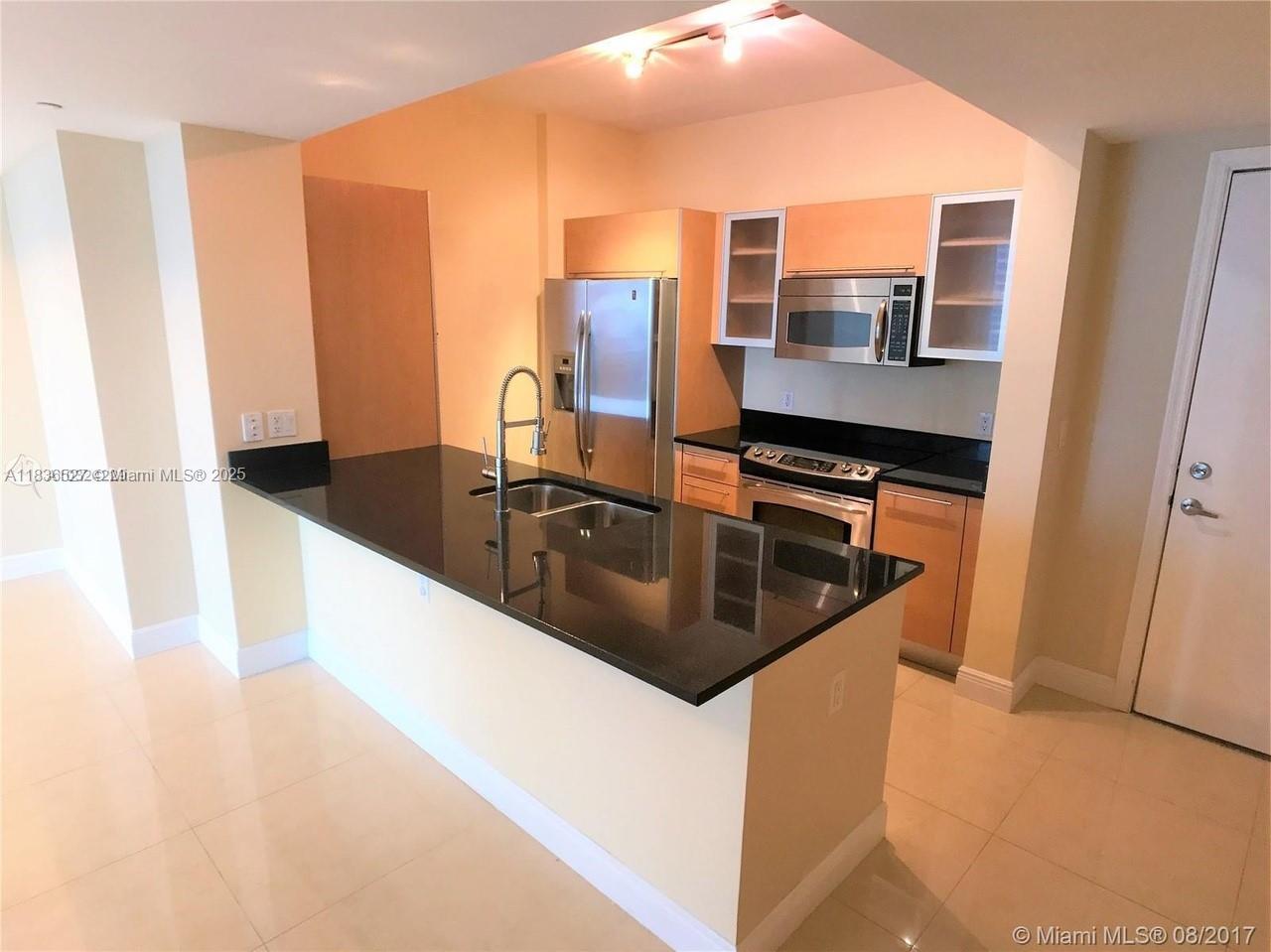 951 Brickell Avenue, Unit 2405 Miami, FL 33131 - Photo 16 of 38 a kitchen with a sink and a refrigerator