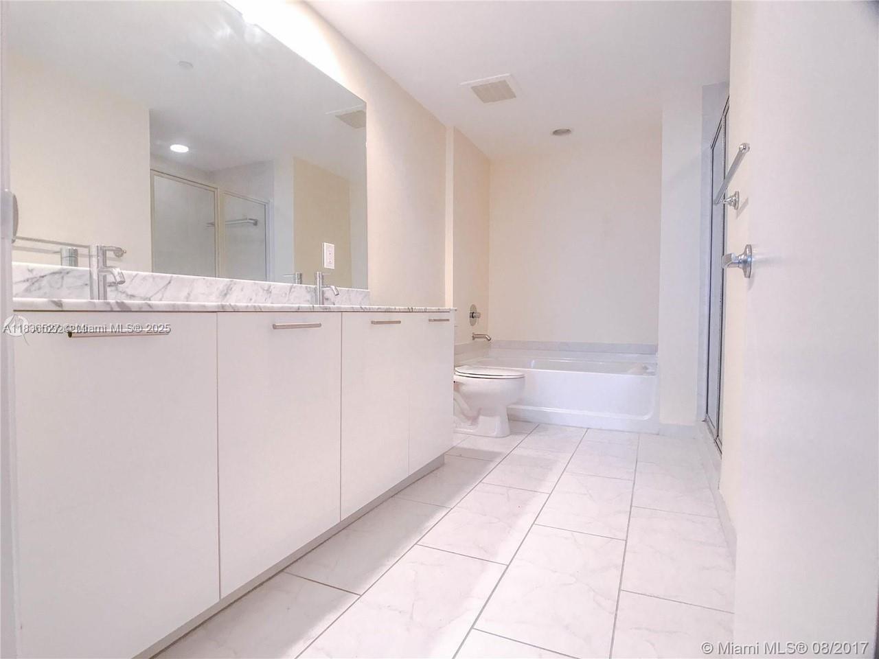 951 Brickell Avenue, Unit 2405 Miami, FL 33131 - Photo 21 of 38 a bathroom with a granite countertop sink mirror and toilet