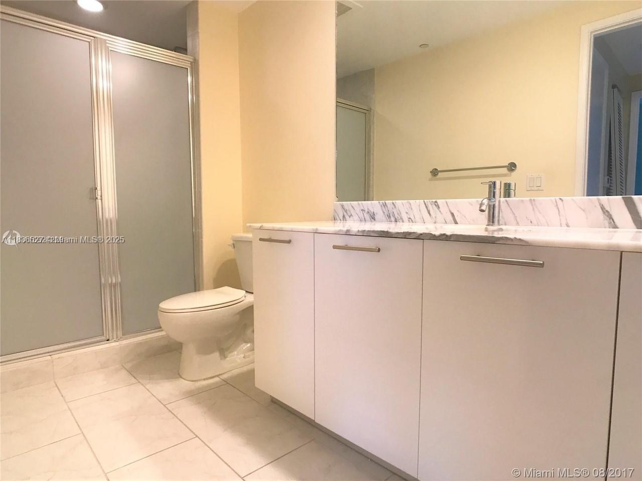 951 Brickell Avenue, Unit 2405 Miami, FL 33131 - Photo 28 of 38 a bathroom with a toilet a sink and shower