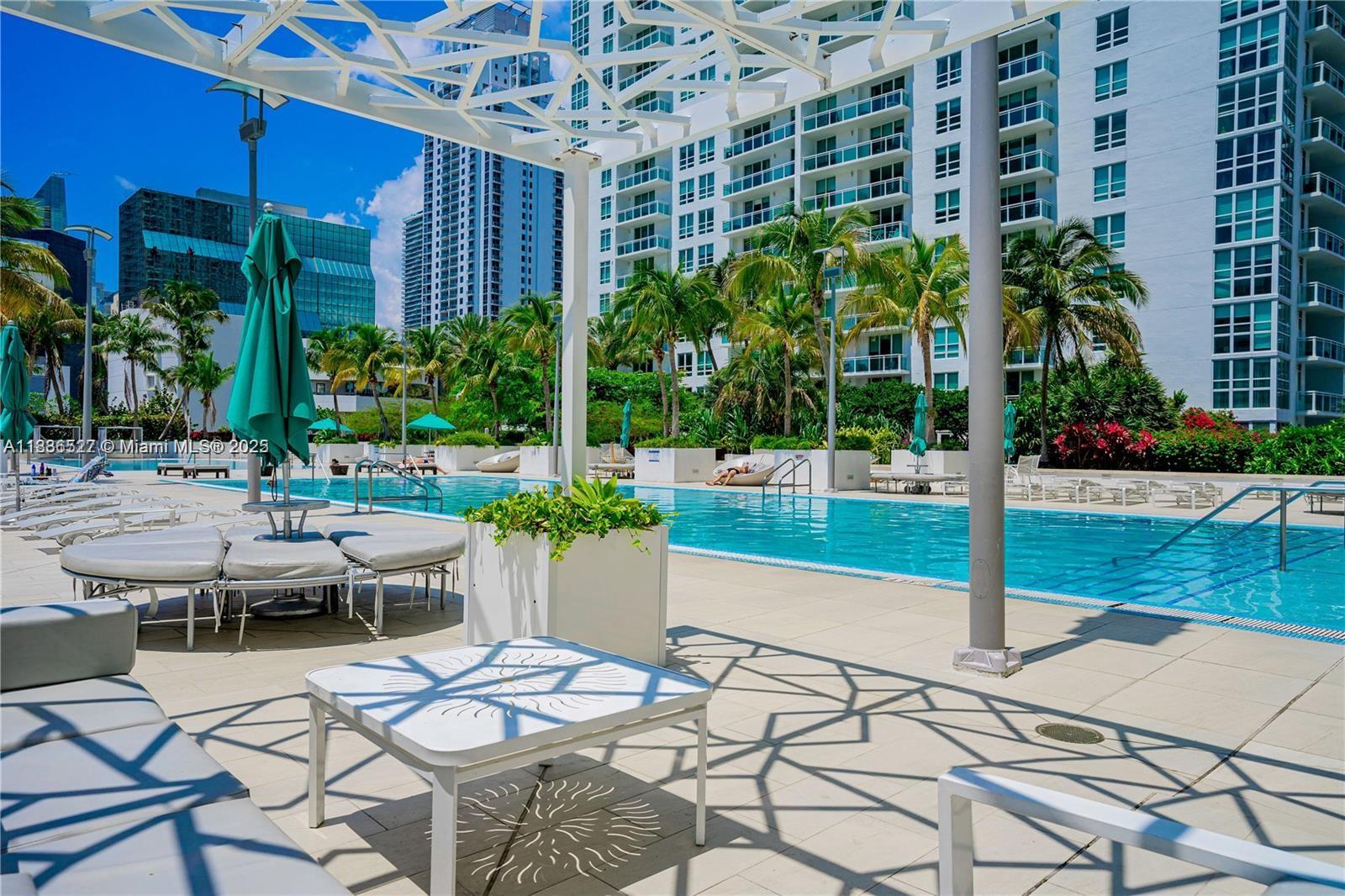 951 Brickell Avenue, Unit 2405 Miami, FL 33131 - Photo 36 of 38 a view of a patio with table and chairs potted plants and palm tree