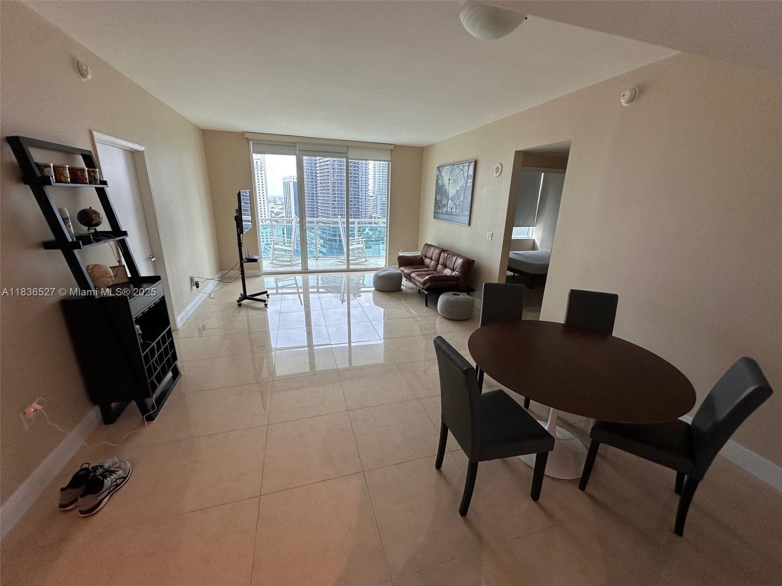 951 Brickell Avenue, Unit 2405 Miami, FL 33131 - Photo 6 of 38 a living room with furniture and a flat screen tv