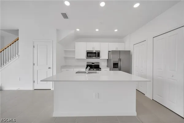 a large white kitchen with stainless steel appliances