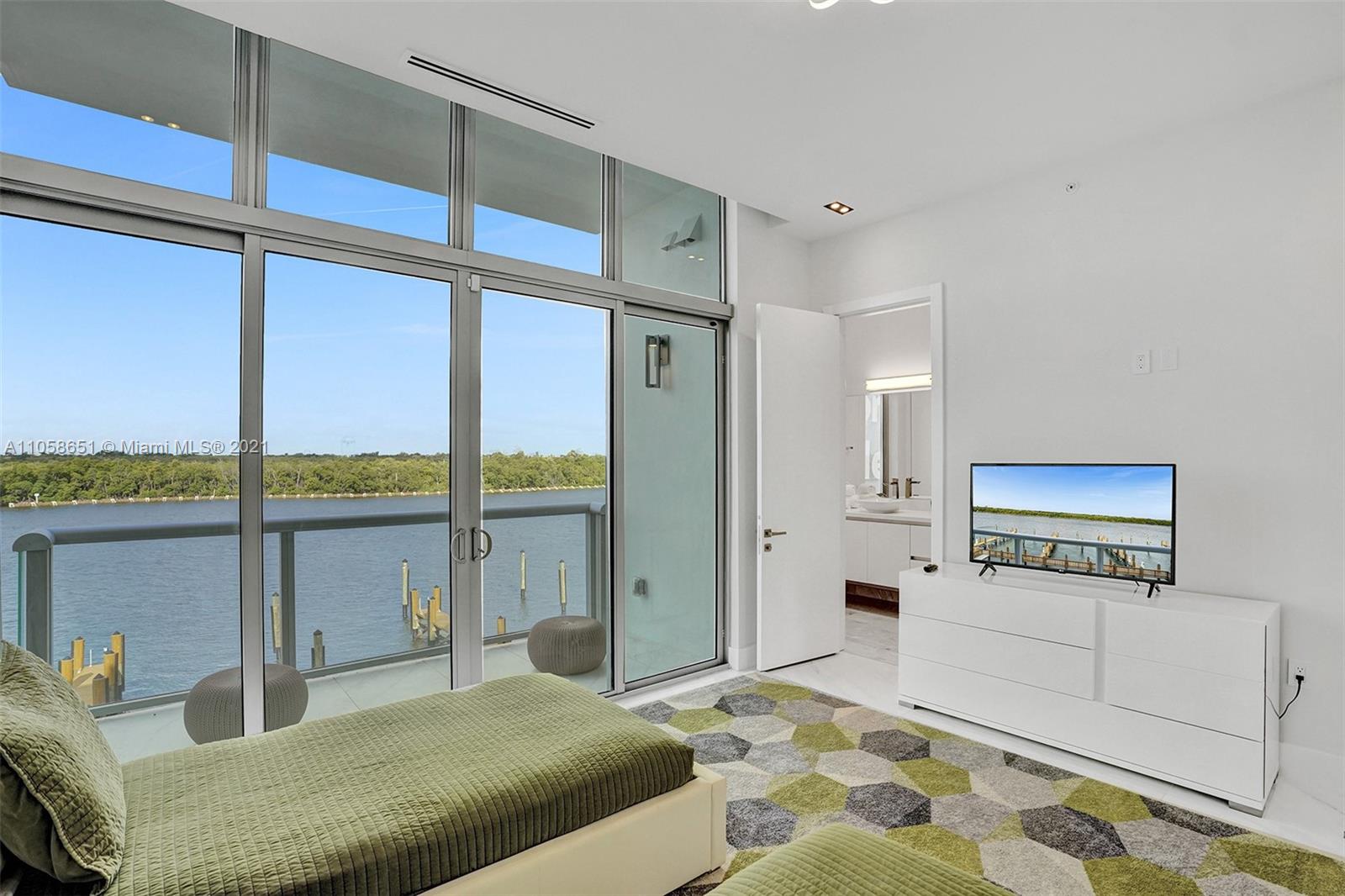 2870 North Ocean Drive Hollywood, FL 33019 - Photo 32 of 57 a bedroom with a bed mirror on desk and a large window