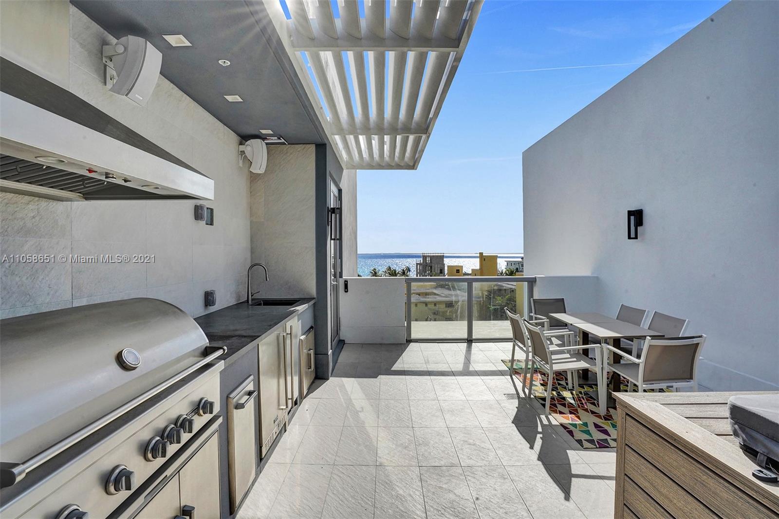 2870 North Ocean Drive Hollywood, FL 33019 - Photo 34 of 57 a kitchen with a sink a stove and chairs
