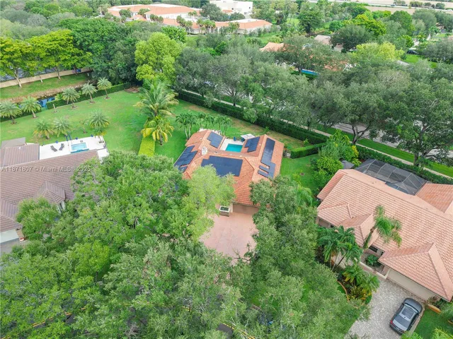 an aerial view of a house with a garden and lake view