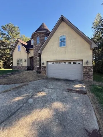 a view of a house with a yard and a large tree
