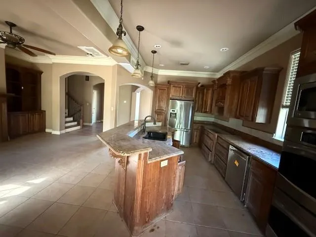 a kitchen with stainless steel appliances granite countertop a sink and a refrigerator