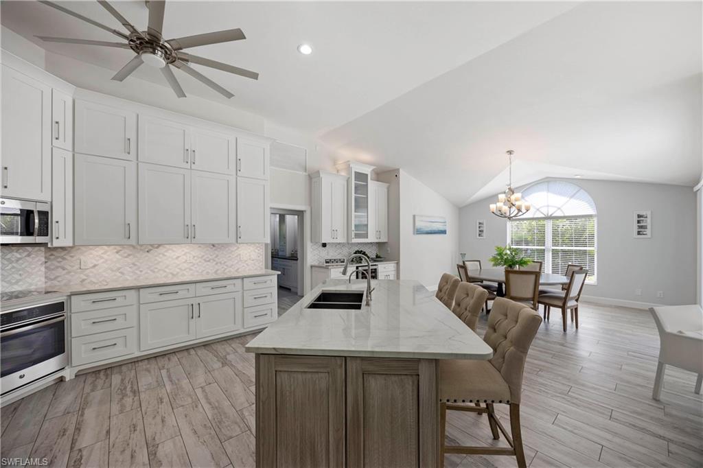 1850 Crayton Road Naples, FL 34102 - Photo 15 of 48 a kitchen with sink cabinets dining table and chairs