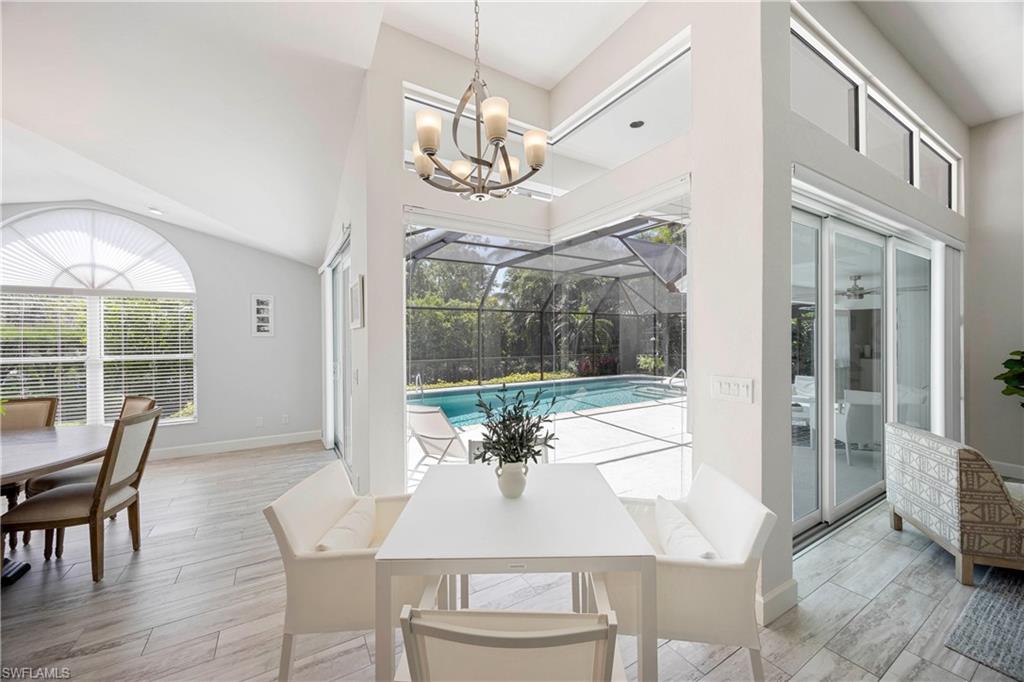 1850 Crayton Road Naples, FL 34102 - Photo 19 of 48 a view of a dining room with furniture wooden floor and chandelier