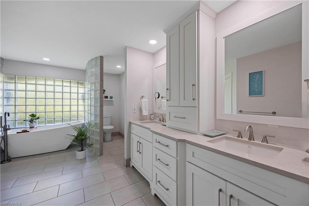 1850 Crayton Road Naples, FL 34102 - Photo 23 of 48 a spacious bathroom with a granite countertop sink mirror and bathtub