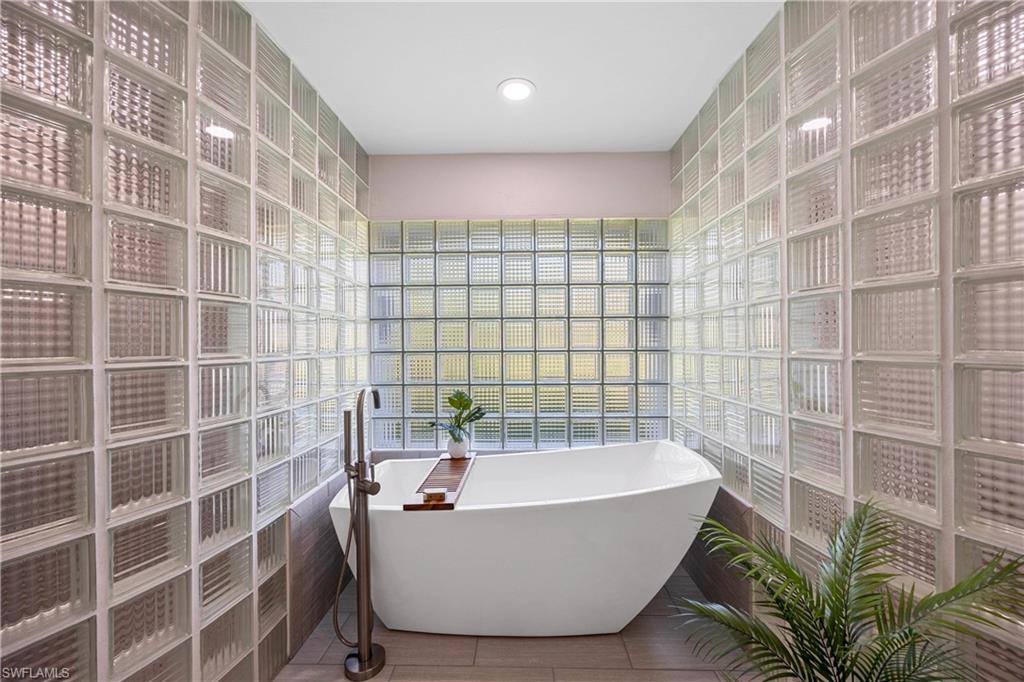 1850 Crayton Road Naples, FL 34102 - Photo 24 of 48 a bathroom with a bathtub and shower