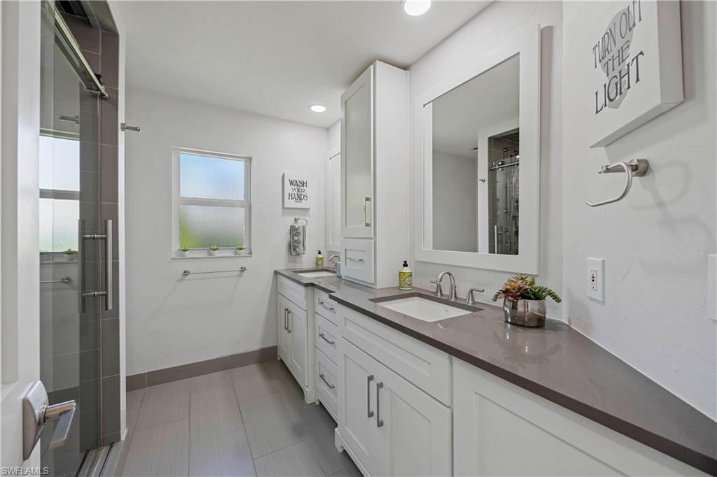1850 Crayton Road Naples, FL 34102 - Photo 30 of 48 a bathroom with double sink and a mirror