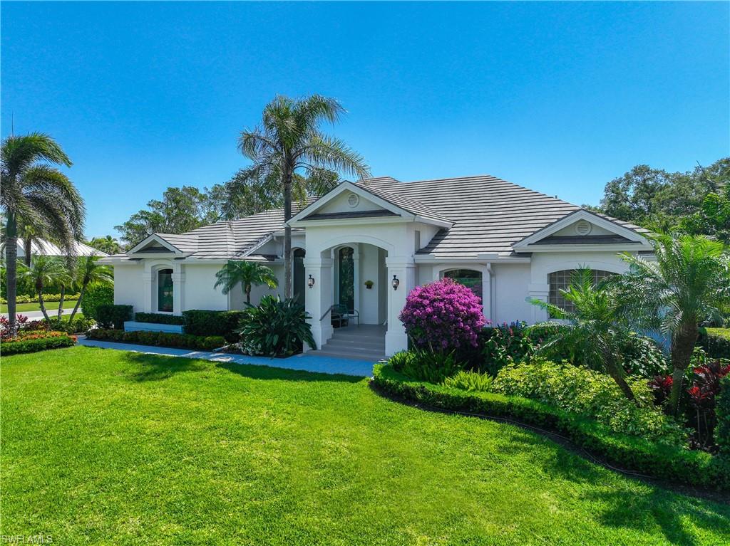 1850 Crayton Road Naples, FL 34102 - Photo 4 of 48 a front view of a house with a garden and plants