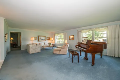 a living room with furniture and a piano