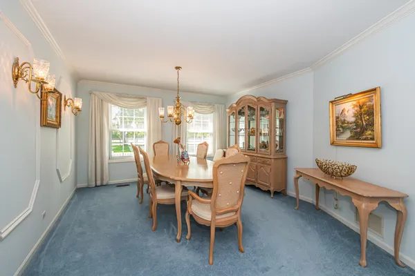 a dining room with furniture a chandelier and window