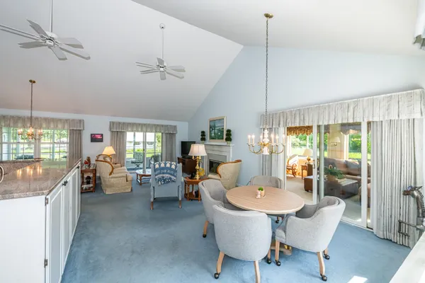 a very nice looking dining room with a large window a table and chairs