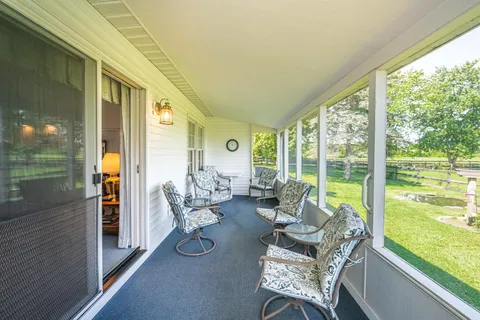 a living room with furniture and a floor to ceiling window