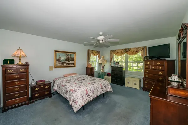 a bedroom with a bed and a flat tv screen on dresser