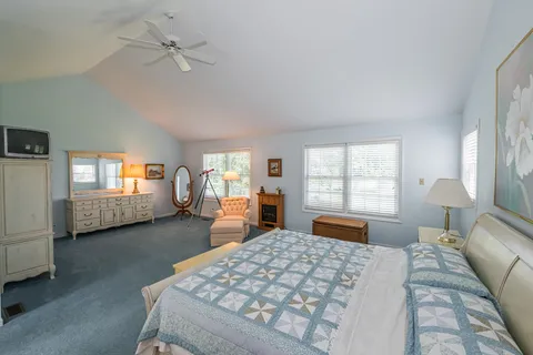 a bedroom with a large bed and a chandelier