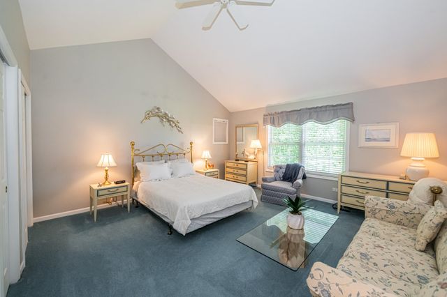 a spacious bedroom with a bed and wooden floor