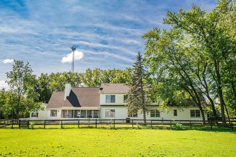 a view of a house with pool and chairs
