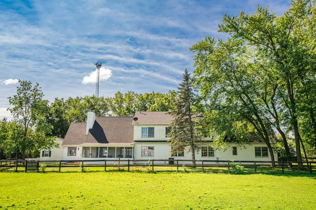 a view of a house with pool and chairs
