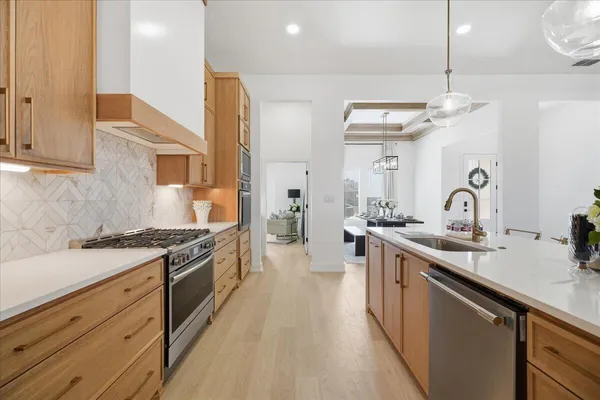 a kitchen with stainless steel appliances granite countertop a sink stove and refrigerator