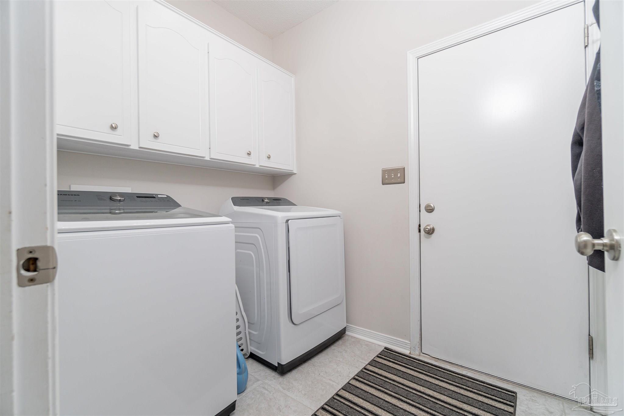 1504 Muirfield Road Cantonment, FL 32533 - Photo 11 of 17 a utility room with cabinets washer and dryer