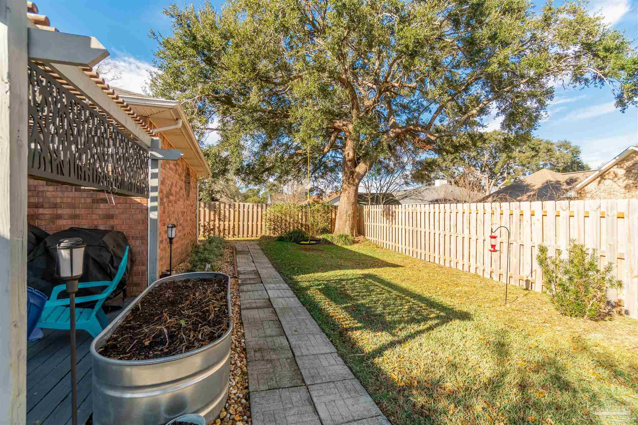 1504 Muirfield Road Cantonment, FL 32533 - Photo 16 of 17 a view of a backyard with plants and iron fence