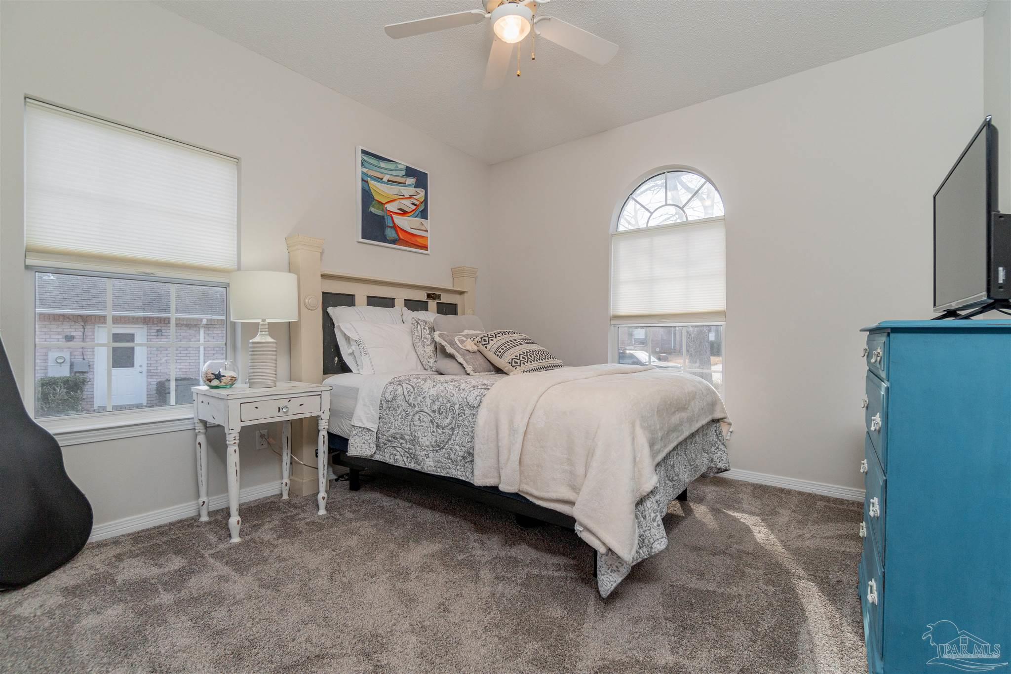 1504 Muirfield Road Cantonment, FL 32533 - Photo 4 of 17 a bedroom with a bed and a chandelier