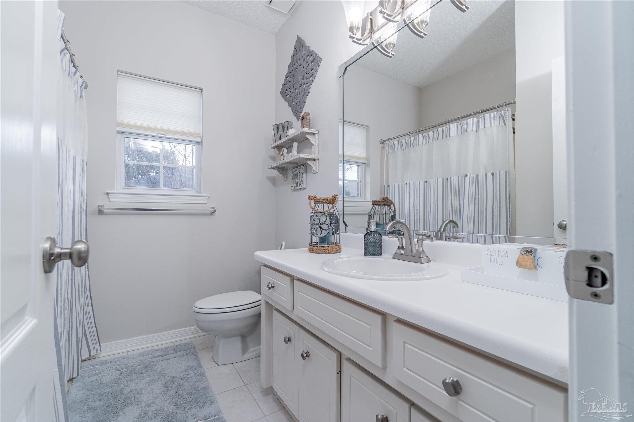 1504 Muirfield Road Cantonment, FL 32533 - Photo 5 of 17 a view of bathroom with a sink mirror and toilet