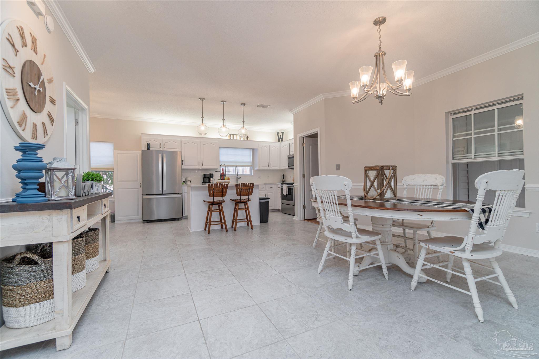 1504 Muirfield Road Cantonment, FL 32533 - Photo 7 of 17 a dining room with furniture and chandelier