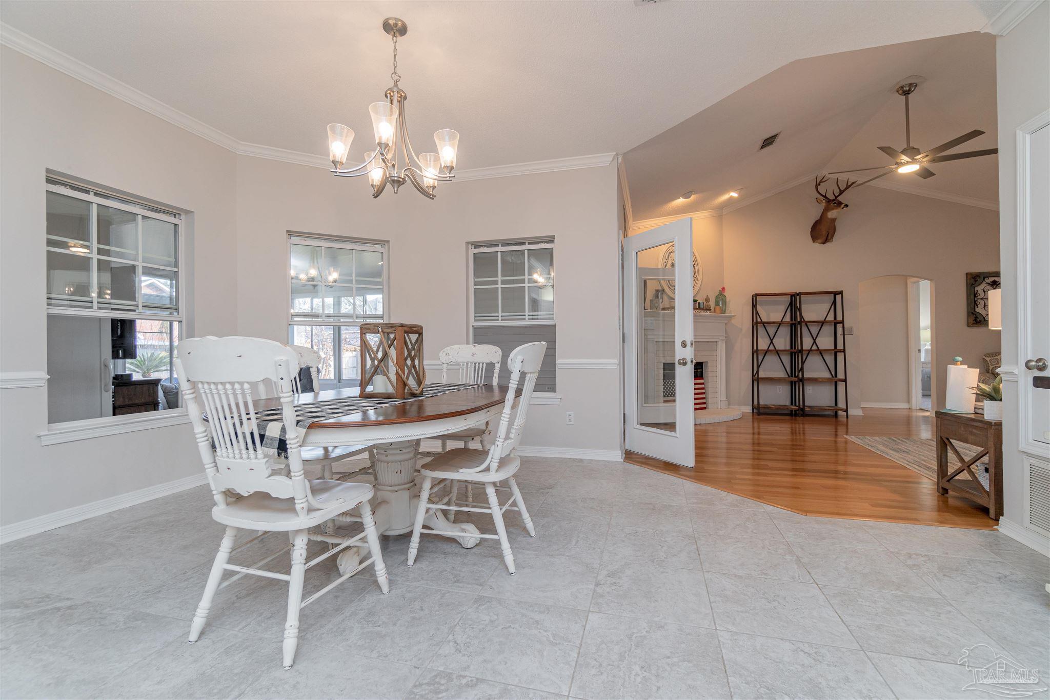 1504 Muirfield Road Cantonment, FL 32533 - Photo 8 of 17 a view of a dining room with furniture and chandelier