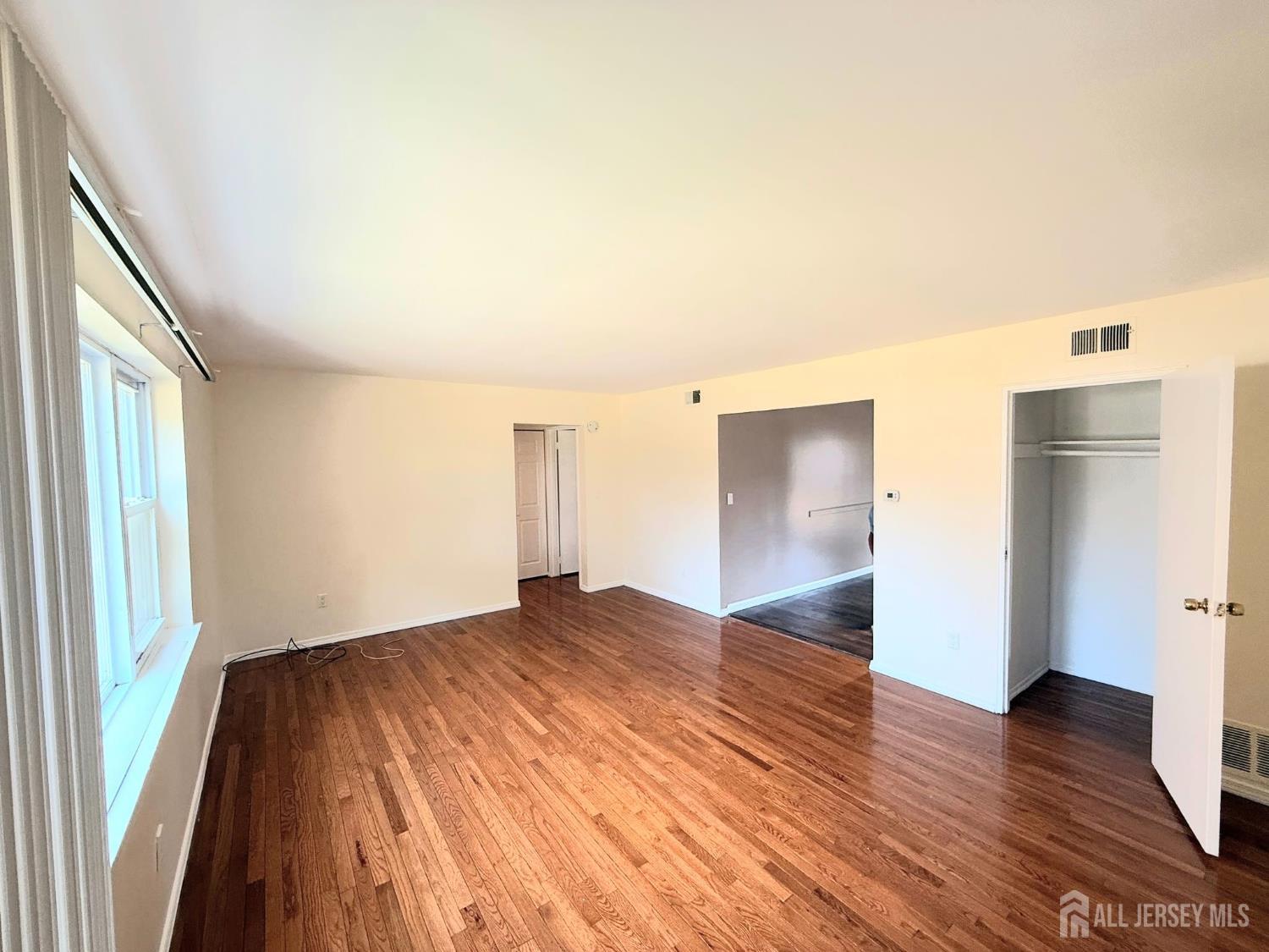 182 Evergreen Road, Unit 15A Edison, NJ 08837 - Photo 1 of 5 a view of an empty room with wooden floor and a window