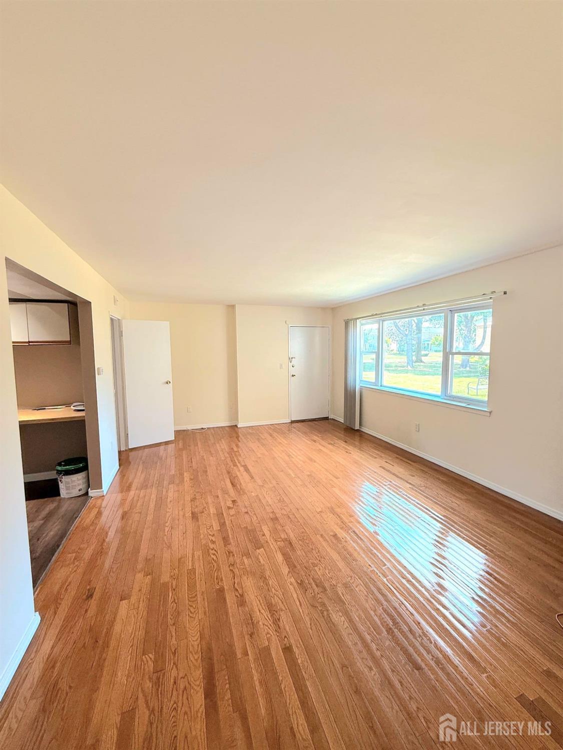 182 Evergreen Road, Unit 15A Edison, NJ 08837 - Photo 2 of 5 an empty room with wooden floor and windows