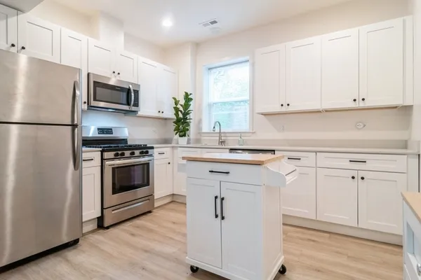 a kitchen with white cabinets and white appliances