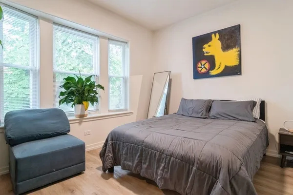 a bedroom with a bed and a couch with window