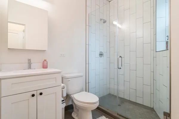 a bathroom with a sink a toilet and shower