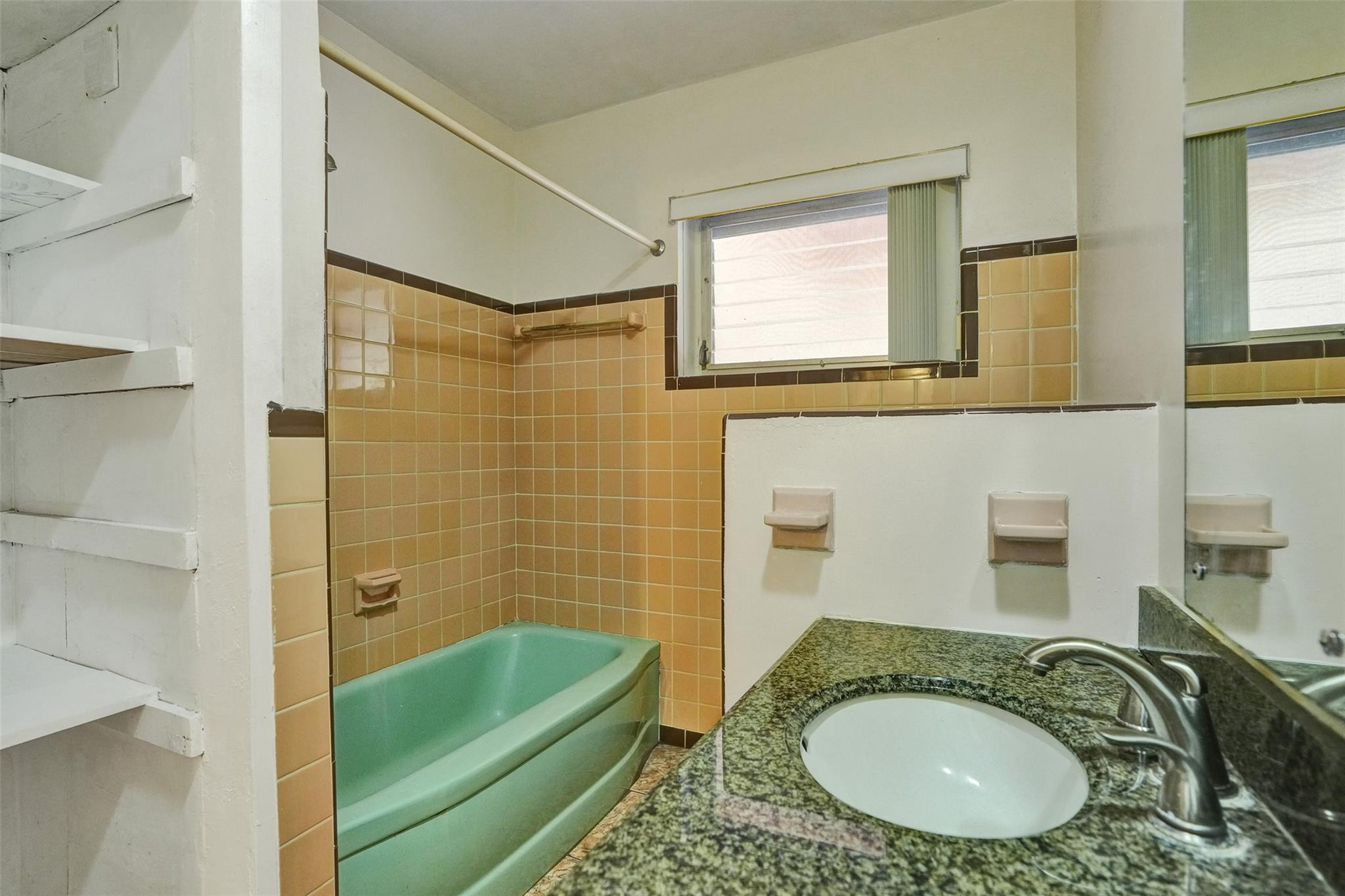 225 Pocatella Street Miami Springs, FL 33166 - Photo 31 of 56 a bathroom with a granite countertop sink a mirror and a bathtub