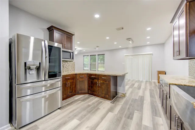 a kitchen with stainless steel appliances granite countertop a sink stove and refrigerator