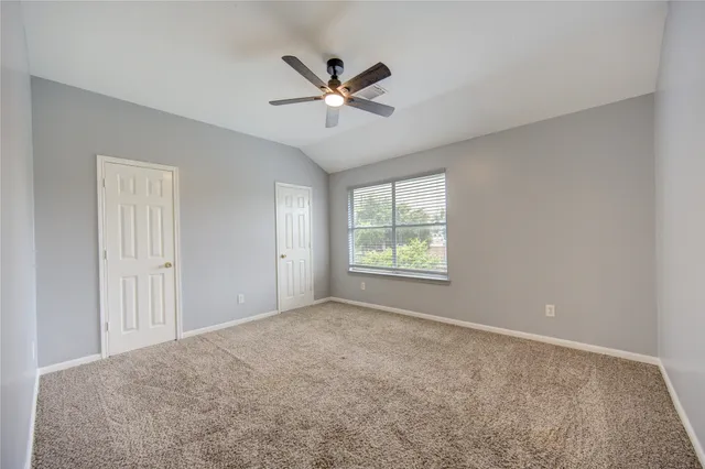 an empty room with closet and ceiling fan