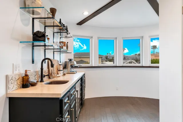 a hall with kitchen island a sink a counter space and a window