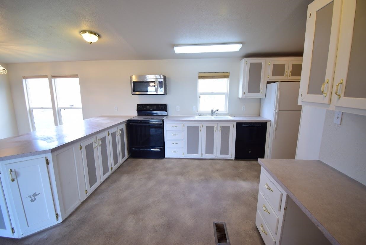 19548 B50 Road Delta, CO 81416 - Photo 6 of 37 a kitchen with granite countertop a sink stove and refrigerator