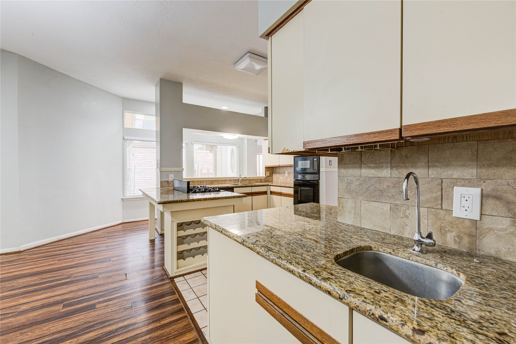 2122 Paso Rello Drive Houston, TX 77077 - Photo 19 of 20 a kitchen with granite countertop a sink and a stove top oven with wooden floor