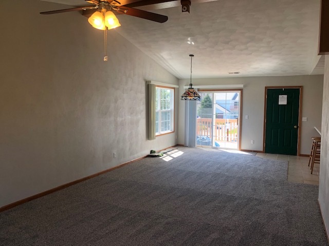 10149 Monarch Road, Unit 4 Roscoe, IL 61073 - Photo 6 of 21 an empty room with a chandelier fan and a large window