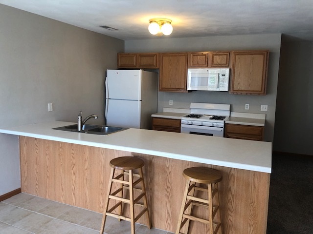 10149 Monarch Road, Unit 4 Roscoe, IL 61073 - Photo 8 of 21 a kitchen with a table chairs and a refrigerator