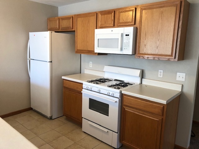 10149 Monarch Road, Unit 4 Roscoe, IL 61073 - Photo 9 of 21 a kitchen with stainless steel appliances white cabinets and a refrigerator