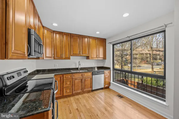 a kitchen with wooden cabinets stove top oven and sink