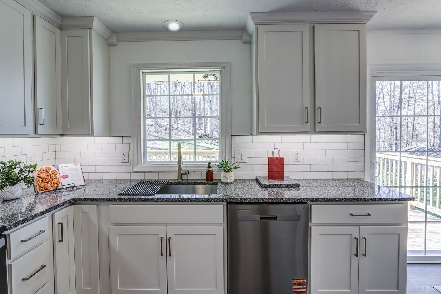 303 Grove Street Hurt, VA 24563 - Photo 19 of 51 a kitchen with granite countertop a sink window and cabinets